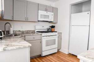 Il comprend une cuisine équipée d'appareils électroménagers blancs et d'un réfrigérateur blanc. dans l'établissement Large 2 Bedroom Great Location Close to Everything, à Pittsburgh