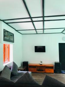 een woonkamer met een bank en een tv bij Bambo Cabana in Kandy