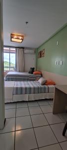 two beds in a room with a window at Barreirinhas Gran Lençóis Flat Residence Mandacaru 506 Particular in Barreirinhas