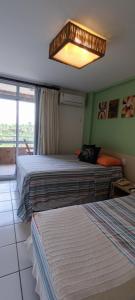 ein Hotelzimmer mit 2 Betten und einem Kronleuchter in der Unterkunft Barreirinhas Gran Lençóis Flat Residence Mandacaru 506 Particular in Barreirinhas