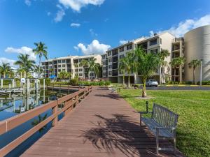 um banco num passeio ao lado de um edifício em Santa Maria 110 em Fort Myers Beach