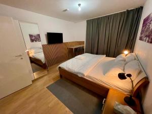 1 dormitorio con 1 cama y 1 habitación con espejo en Spacious 1BR Apartment with Balcony above Citygate Shopping Complex with Metro Access en Viena