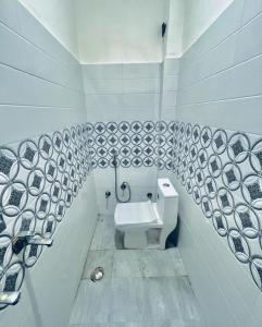 een witte badkamer met een toilet en een wastafel bij Paradise residency and cafe in Gwalior