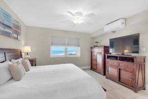 um quarto com uma cama e uma televisão de ecrã plano em Regency Towers 808 West em Pensacola Beach