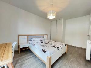 Schlafzimmer mit einem Bett und einem Holztisch in der Unterkunft Le Cartoucherie - 4p - Parking - Tram & Zénith in Toulouse