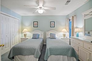Un dormitorio con dos camas y un ventilador de techo. en Grand Caribbean East 214, en Pensacola 29 fotos más