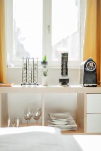 eine Küchentheke mit Weingläsern und einer Uhr darauf in der Unterkunft Classy Modern Studio - Free Parking in Wien