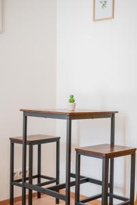 einem Konsole-Tisch mit zwei Hockern darunter in der Unterkunft Classy Modern Studio - Free Parking in Wien