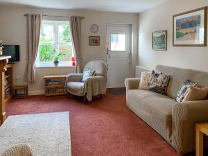 a living room with a couch and a chair at Middle Cottage in Thirsk