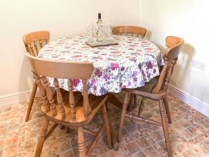 a dining room table with a floral table cloth on it at Middle Cottage in Thirsk