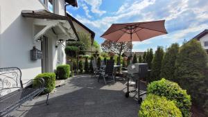 een patio met een tafel, een parasol en een grill bij Ferienwohnung Friedhoff, 80qm in Schmallenberg