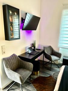 a room with a desk with a laptop and two chairs at LIVE-IN Tiny Studiowohnung in Wertheim