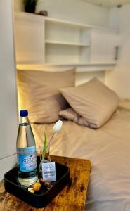 een fles water op een dienblad op een bed bij LIVE-IN Tiny Studiowohnung in Wertheim
