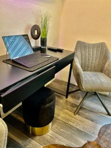 un ordinateur portable assis sur un bureau avec une chaise dans l'établissement LIVE-IN Tiny Studiowohnung, à Wertheim