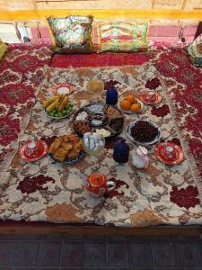 een tafel met borden eten op een bed bij Hotel ISMOIL SAMONI in Bukhara