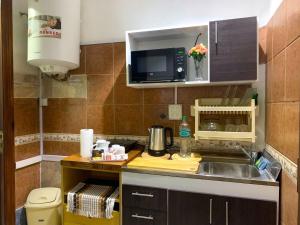 a small kitchen with a sink and a microwave at Antiguo Maipu in Buenos Aires