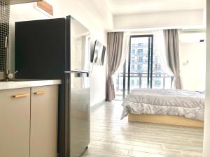 a kitchen with a refrigerator in a room with a bed at STAR BAY Residence Sihanoukville - 400m to Sokha Beach in Sihanoukville