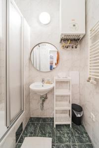ein Bad mit einem Waschbecken und einem Spiegel in der Unterkunft Cosy Central Studio in Wien