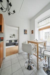 uma cozinha e sala de estar com mesa e cadeiras em Cosy Central Studio em Viena