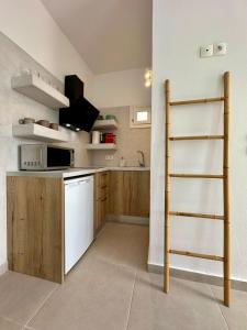 a kitchen with a white refrigerator and a ladder at Family Villages Santorini in Vlychada Beach