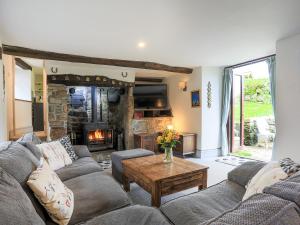 a living room with a couch and a fireplace at Higher Rowes Farm in Marytavy