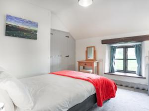 a white bedroom with a bed and a window at Higher Rowes Farm in Marytavy