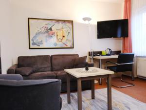 ein Wohnzimmer mit einem Sofa und einem Tisch in der Unterkunft Hotel Burgklause in Nickenich