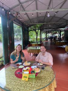 a man and a woman sitting at a table with food at TamCoc Việt Tân Homestay & Garden in Ninh Binh