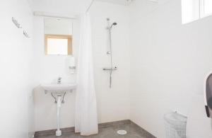 a white bathroom with a shower and a sink at Lövhults Camping & Stugby in Nässjö +6 photos