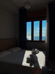 a bedroom with a bed and a window with towels at Palazzo Durante in Letojanni