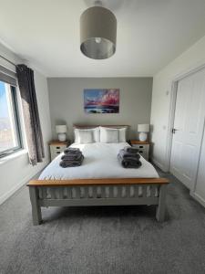 a bedroom with a large bed with white sheets at Sgothan Dearg in Portree