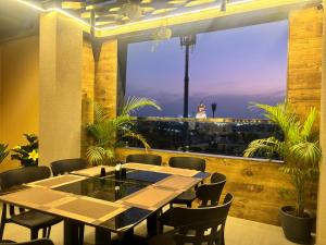 a table and chairs in a restaurant with a view at Maruti Group of Hotels - The Shivam in Nāthdwāra