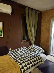 a bedroom with a bed with a checkered blanket at Etno selo naša avlija in Blace