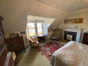 a bedroom with a bed and a fireplace at Glenaros Lodge in Salen