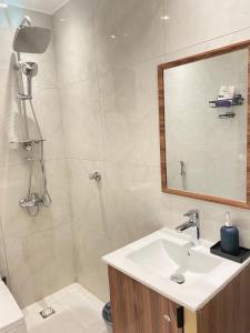 a bathroom with a sink and a shower with a mirror at شقه حي المروج B in Riyadh