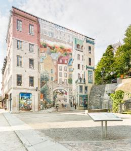 a bench in front of a building with a mural at Les Lofts Champlain - Par Les Lofts Vieux-Québec in Quebec City