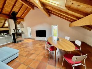ein Wohnzimmer mit einem Holztisch und Stühlen in der Unterkunft Grosszügige Dachwohnung in Tessiner Altbau in Monte Ceneri