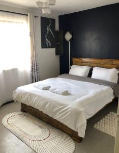 a bedroom with a large bed with white sheets at Sandrock Residence in Nairobi