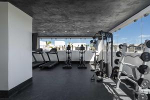 a gym with treadmills and cardio equipment in a building at 2BD with Rooftop Pool near Beach in Tulum