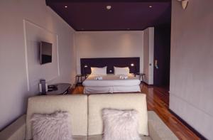 a bedroom with a bed and a couch in it at Hotel Arcipreste de Hita - Adults Only in Navacerrada