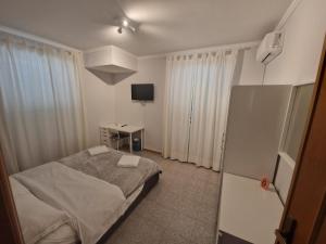 Dormitorio pequeño con cama y TV en Alloggio Hello Roma 2.0 en Roma