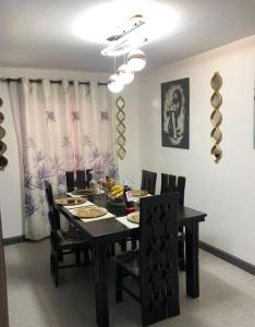 comedor con mesa negra y sillas en Sandrock Residence en Nairobi