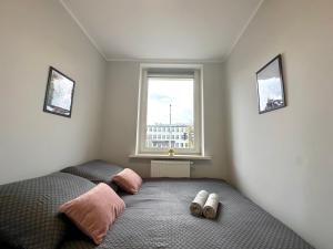 1 dormitorio con 1 cama con 2 pares de zapatillas en MMRent Florence Room, en Gdansk
