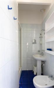 a white bathroom with a sink and a toilet at Olympia Hotel in Genoa