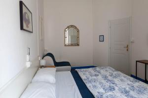 a bedroom with two beds and a mirror at Olympia Hotel in Genoa