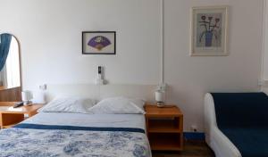 a bedroom with a bed and two tables and a window at Olympia Hotel in Genoa