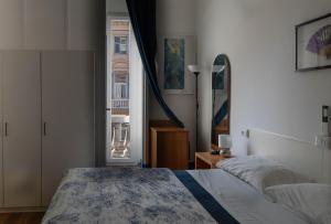 a bedroom with a bed and a window at Olympia Hotel in Genoa