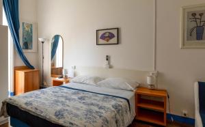a bedroom with a bed with a blue and white blanket at Olympia Hotel in Genoa