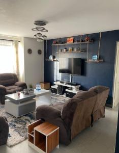 a living room with a couch and a tv at Sandrock Residence in Nairobi