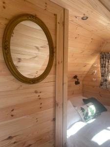 un espejo en la pared de una cabaña de madera en Cabane Insolite Cosy, en Ramonchamp
